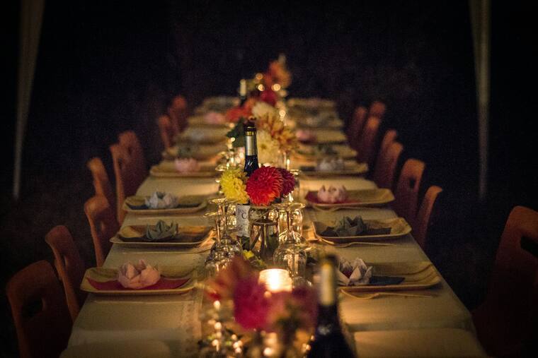Lange Tafel mit Kerzen und Blumen für eine private Feier
